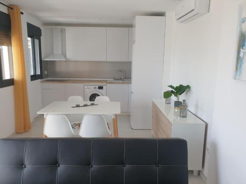 a kitchen with a white table and white chairs at APARTAMENTOS LA CALA de MIJAS in La Cala de Mijas