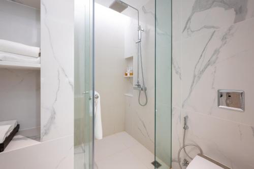 a bathroom with a shower with a glass door at Grand Richmond Stylish Convention Hotel in Nonthaburi
