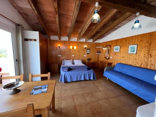 a living room with a bed and a blue couch at Apartamentos Can Marsalet in Portocolom