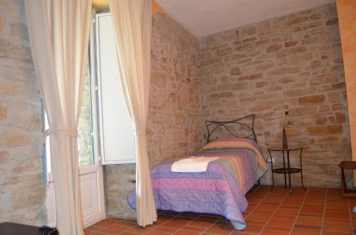 a bedroom with a bed in a brick wall at B&B La casa di Giulietta in Castelmezzano