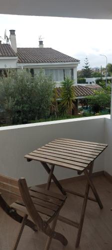 a wooden picnic table and a chair on a balcony at Casa adosada Gran Avenida con billar in Benicàssim