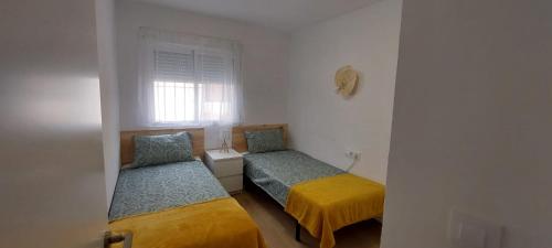 1 dormitorio con 2 camas y ventana en Casa adosada Gran Avenida con billar, en Benicàssim