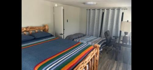 um quarto com uma cama de madeira e um cobertor listrado em The Sequoia guesthouse em Miramonte