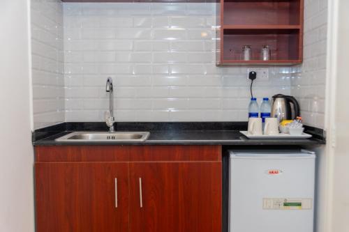 a small kitchen with a sink and a refrigerator at Fujairah Hotel & Resort in Fujairah