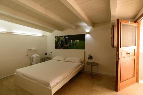 1 dormitorio con 1 cama y una pintura en la pared en Dimora Mariuccia, en Monte SantʼAngelo