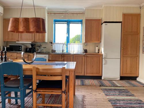 eine Küche mit einem Holztisch und einem Kühlschrank in der Unterkunft Village Cottage In The High Coast Area 