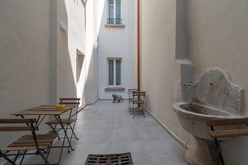 um corredor com mesas e cadeiras num edifício em Palazzetto La Quadra di San Faustino - F&L Apartment em Brescia