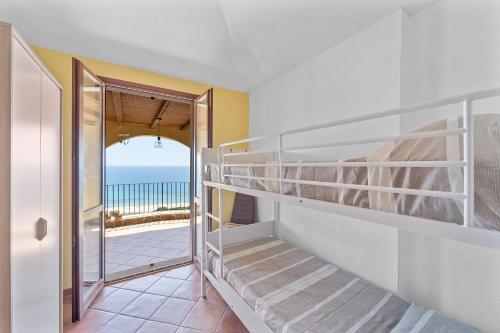 a bedroom with a bunk bed and a view of the ocean at Villa Belvedere in Costa Rei