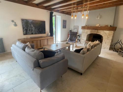 - un salon avec deux canapés, une table et une cheminée dans l'établissement Le Tilleul des Cloux - Au Coeur de Auxey-Duresses, à Auxey-Duresses