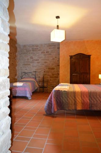a bedroom with two beds and a brick wall at B&B La casa di Giulietta in Castelmezzano