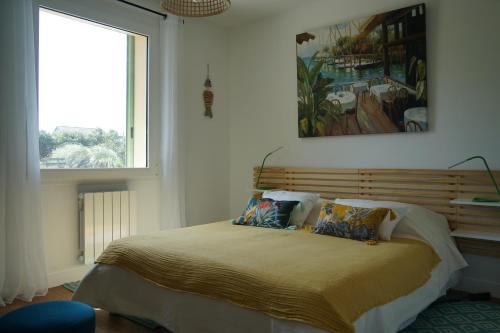 Fermanville的住宿－Villa Joret，卧室配有一张床,墙上挂有绘画作品