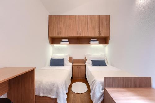 a small room with two beds and wooden cabinets at Villa Mala in Umag