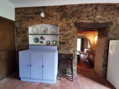 a kitchen with a white cabinet and a stone wall at Viola holiday home in Rialto