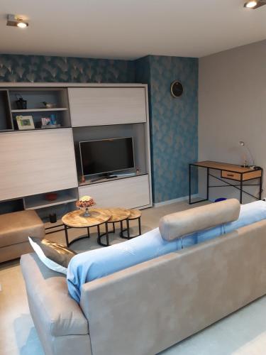 a living room with a couch and a television at WEST BAY App TICO in Westende in Middelkerke