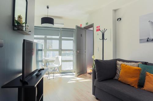 un soggiorno con un divano e una televisione di Blue Salinas ad Aveiro