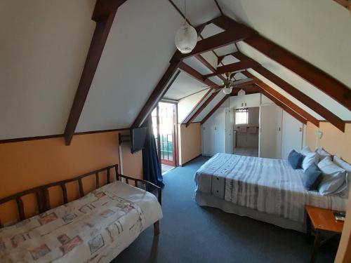 two beds in a room with a attic at Whalers Guest House in Hermanus