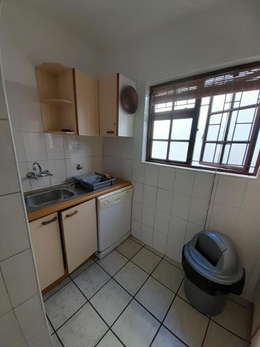 a small kitchen with a toilet and a sink at Whalers Guest House in Hermanus