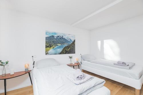 a white room with two beds and two tables at Moderne Ferienwohnung in Lorch in Lorch