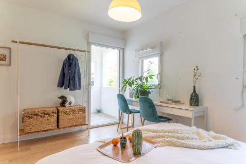 Cette chambre comprend un bureau, une table et des chaises. dans l'établissement Bel appartement lumineux à Biarritz, à Biarritz