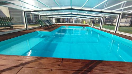 a large swimming pool with blue water at Le Making Of Chambres d'Hôtes insolites et Familiales in Thairé