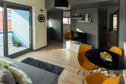 a living room with a couch and a table and chairs at Blue Salinas in Aveiro