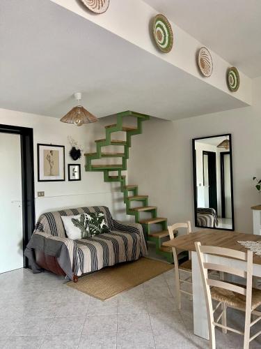 a bedroom with a staircase with a bed and a table at Villa Patty in Marzamemi