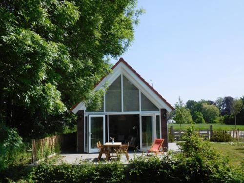 a cottage with a table and chairs in front of it at Gastenverblijf de Vense Weide in Venlo