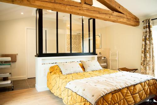 a bedroom with a large bed with a large window at Le Mas de l'écluse in Caux-et-Sauzens