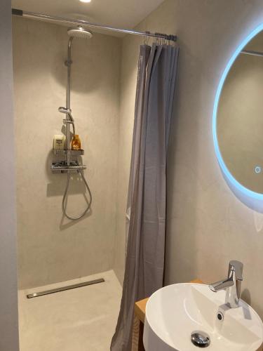 une salle de bain avec un lavabo et une douche avec un miroir dans l'établissement EVEN Bistrot, à Évenos