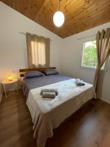 1 dormitorio con 1 cama grande y toallas. en Cozy Wooden House en Durrës