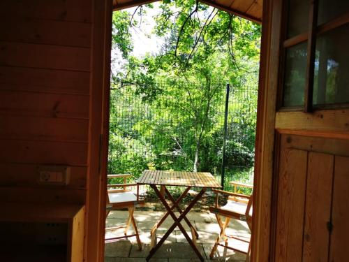 una puerta abierta de un porche con mesa y bancos en Krasen Kras 104 resort, en Komen
