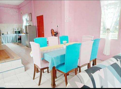 uma sala de jantar com uma mesa azul e cadeiras brancas em Diana Home @ Tuaran em Tuaran