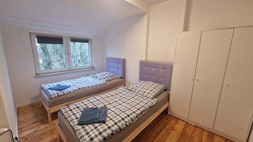 two beds in a room with two windows at Apartment with parking in Berlin 11 in Berlin