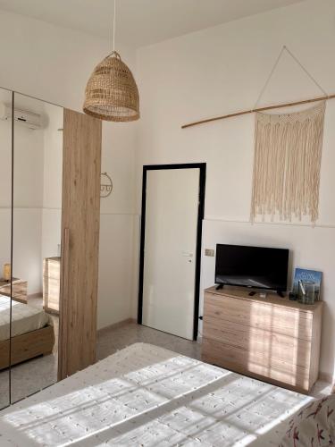 a bedroom with a bed and a tv and a mirror at Villa Patty in Marzamemi