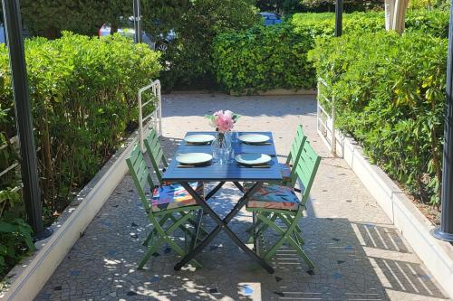 une table et des chaises bleues avec des assiettes et des fleurs. dans l'établissement Appartement Marble - Welkeys, à Nice