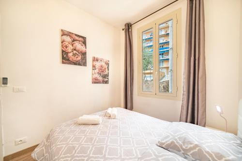 Un dormitorio blanco con una cama y una ventana. en 2mn de Monaco - Centre de Beausoleil - CH, en Beausoleil