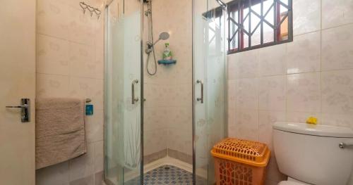 uma casa de banho com uma cabina de duche em vidro e um WC. em Chez Benoit Self Catering em Victoria