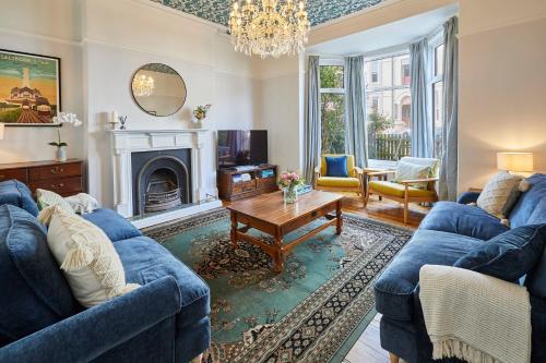uma sala de estar com sofás azuis e uma lareira em Host & Stay - Hidden Gem em Saltburn-by-the-Sea