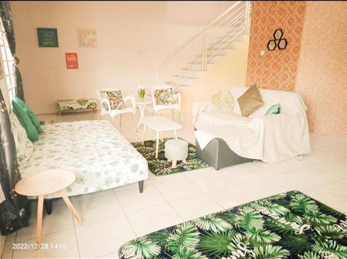 a living room with a couch and a staircase at Diana Home @ Tuaran in Tuaran