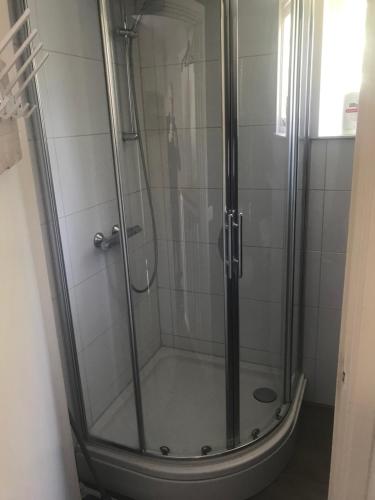 a shower with a glass door in a bathroom at Bed & Breakfast Klokgaaf in De Koog