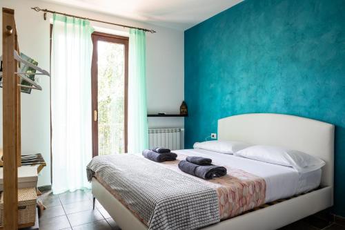 a bedroom with blue walls and a bed with towels on it at Villa De Alberti in Vergiate