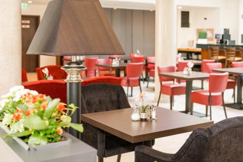 un comedor con mesas, sillas y una lámpara en Hotel Schopenhauer Hof en Frankfurt