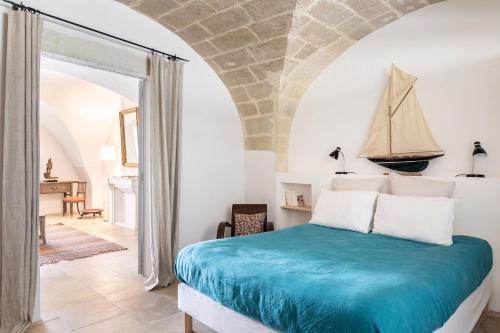 1 dormitorio con 1 cama con un velero en la pared en Les Canisses, magnifique appartement avec terrasse au cœur d'Uzès, en Uzès