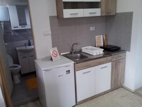 a small kitchen with a sink and a refrigerator at Konak Jerma in Pirot