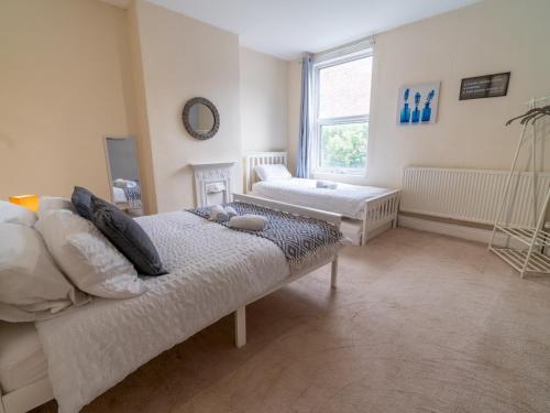 1 dormitorio con 2 camas y ventana en Beautiful 5 Guest Property with free parking en Nottingham