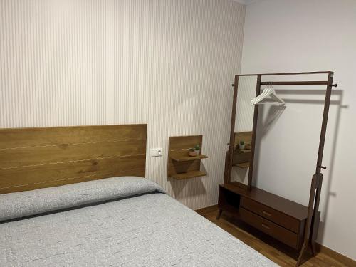 a bedroom with a bed and a dresser and a mirror at Casa Cancela in Palas de Rei 