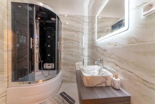 La salle de bains est pourvue d'un lavabo et d'une douche. dans l'établissement LUXURY AND COMFORTABLE VILLA, à Athènes