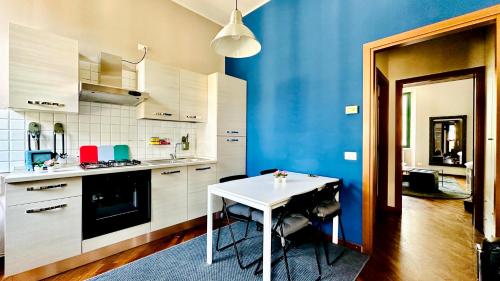a kitchen with a white table and a blue wall at Sweet Apartment Navigli Milano S2 in Milan