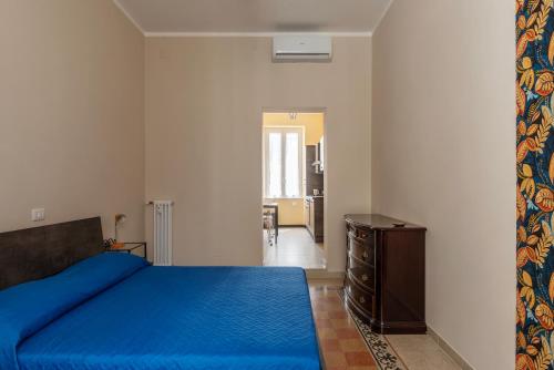 ein Schlafzimmer mit einem blauen Bett und einer Kommode in der Unterkunft Functional Apartment - Piazza Re di Roma in Rom