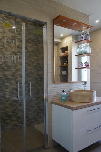W łazience znajduje się szklana kabina prysznicowa i umywalka. w obiekcie Villa Joret w mieście Fermanville